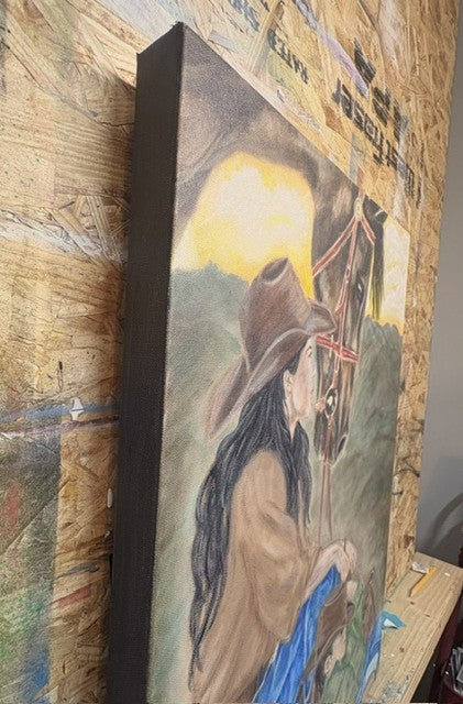 A vertical canvas painting leaning against a wooden workbench, depicting a cowboy in a brown hat and tan jacket with a horse, set against a rustic wood-punchboard background.